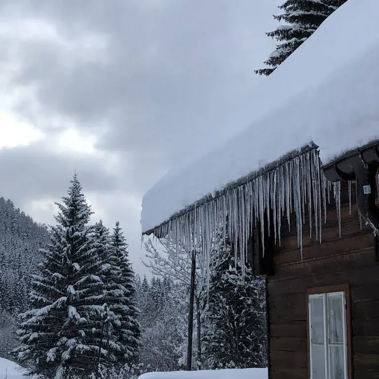 Verschneites Haus mit Eiszapfen